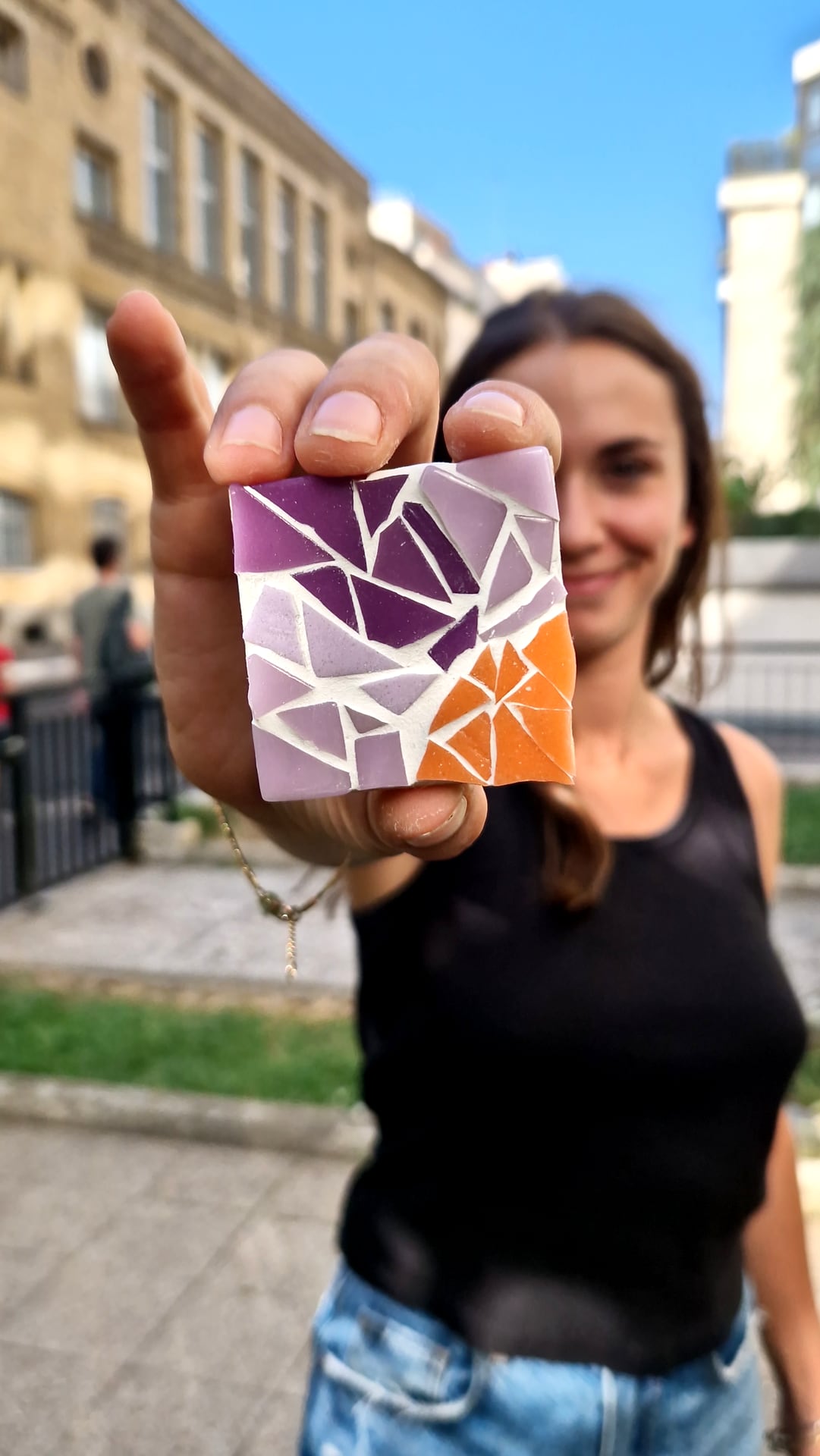 Petite mosaïque violet et orange présentée à bout de bras