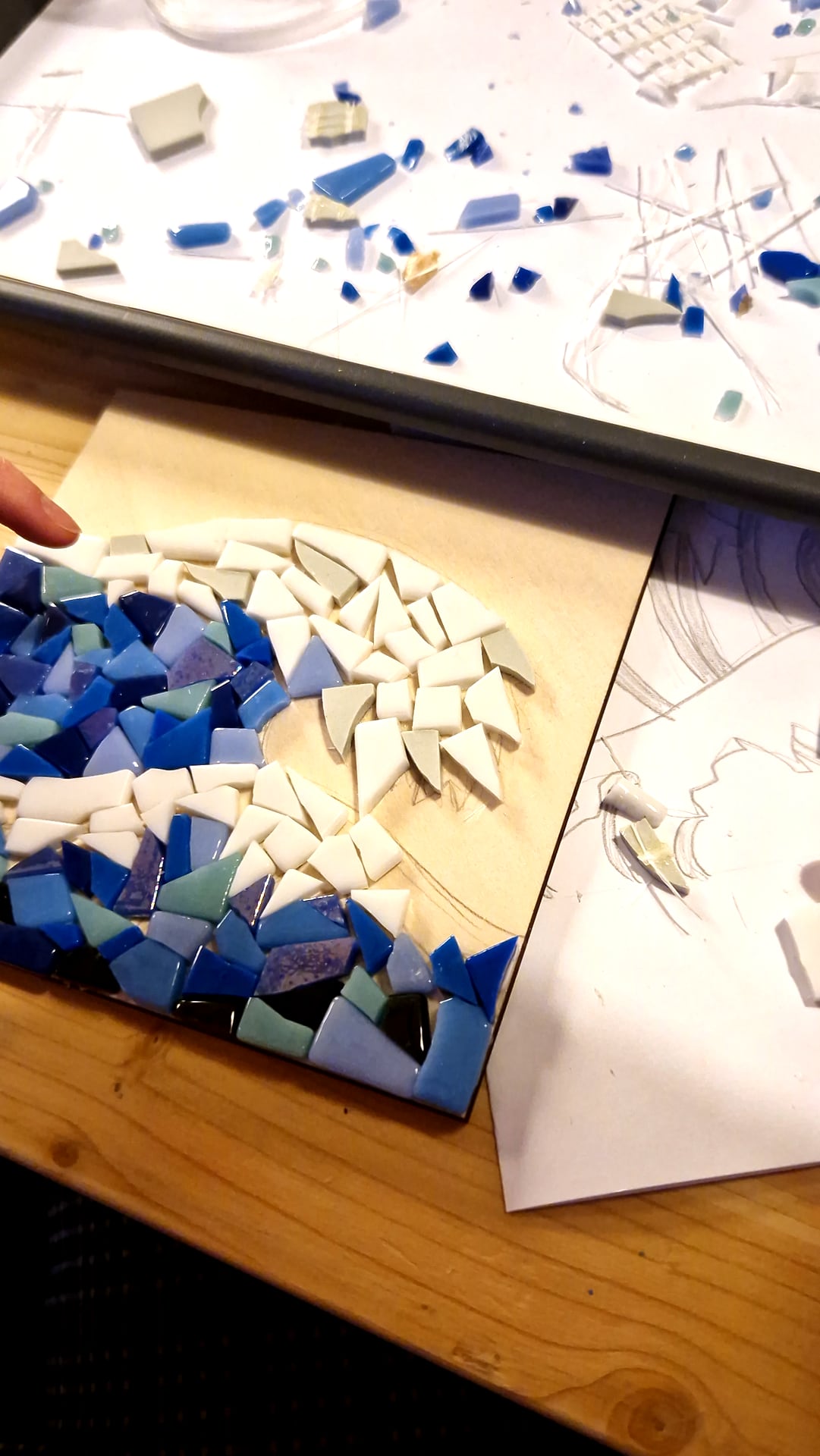 Mosaïque bleue et blanche en cours, tesselles posées sur le bois